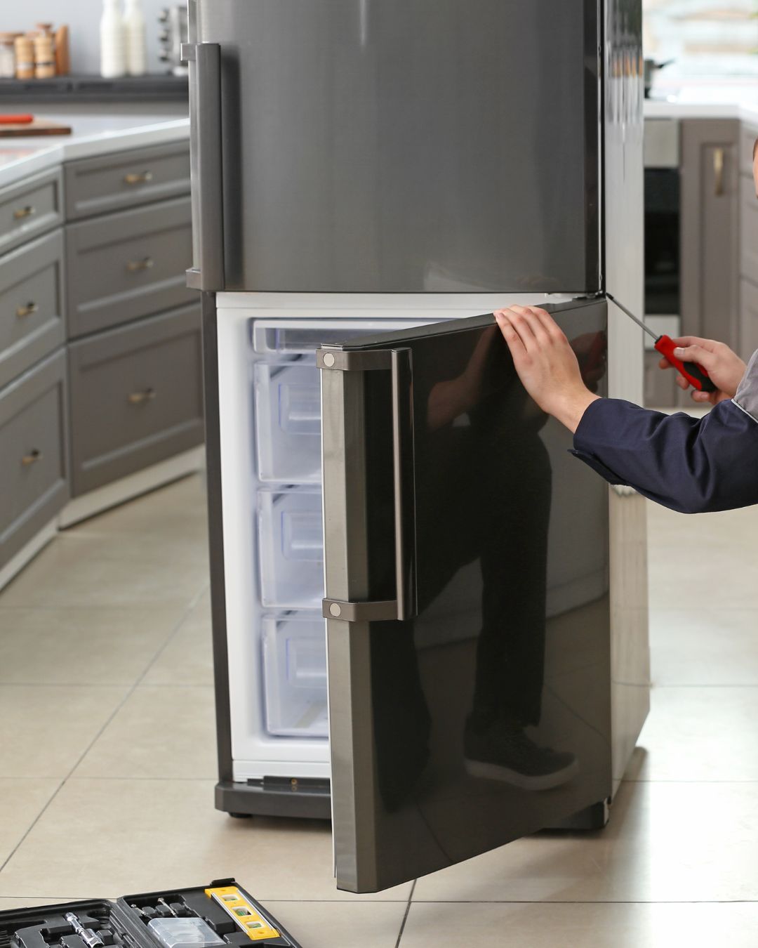 Technicien réparant un réfrigérateur et congélateur résidentiel à Lachenaie